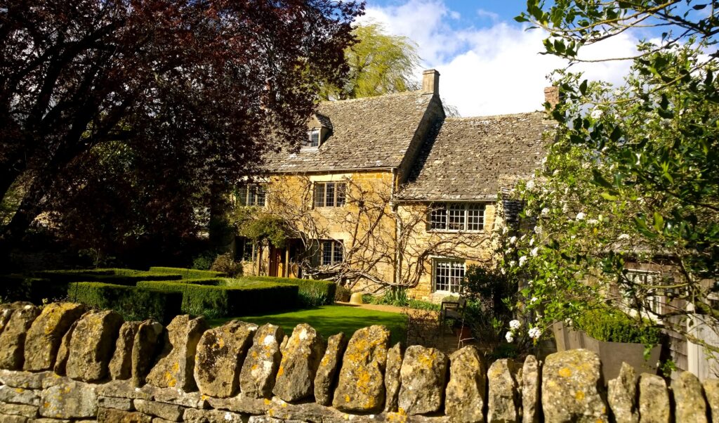 A close up image of a stone Cotswolds cottage in the sunshine
